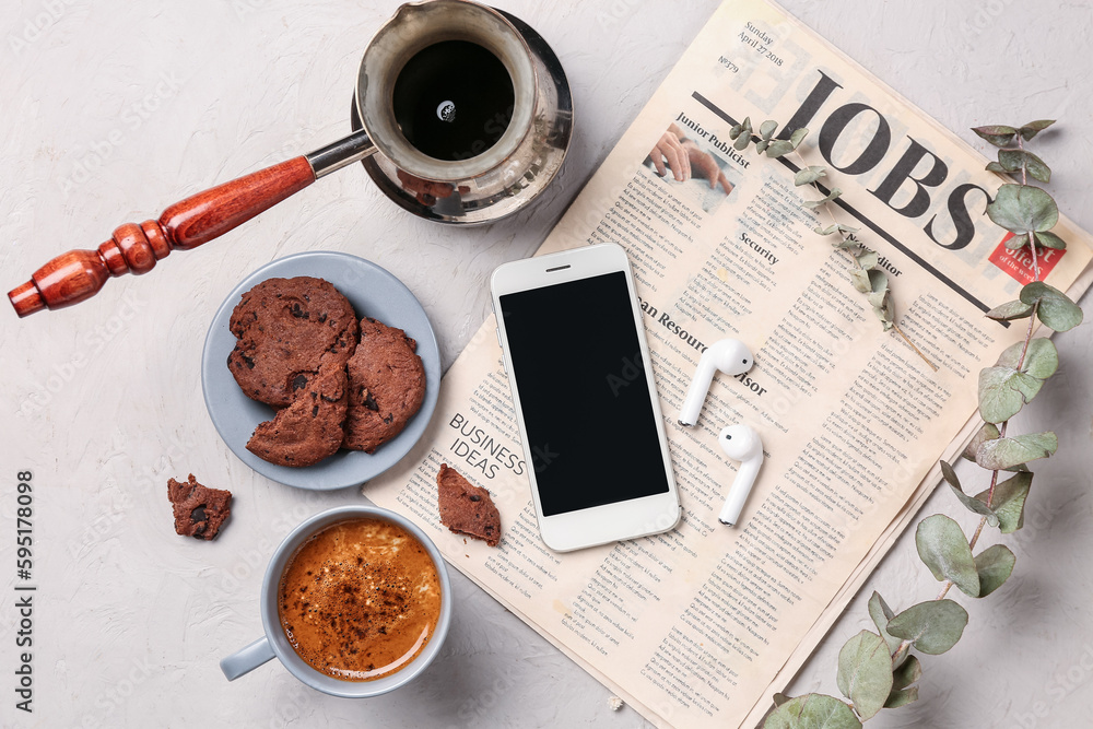 Cup of coffee with cookies, mobile phone, earphones, cezve and newspaper on white background