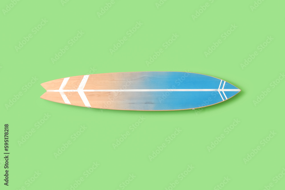 Wooden surfboard hanging on green wall