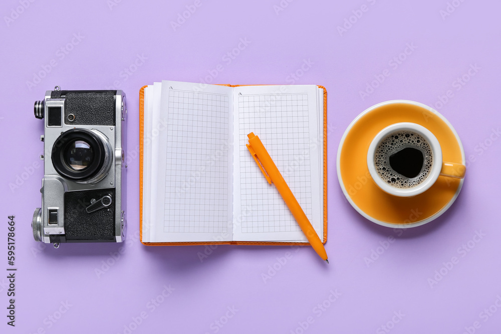 Notebook with pen, photo camera and cup of coffee on lilac background