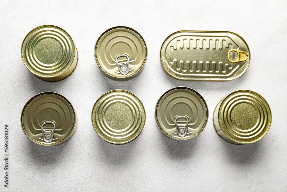 Assortment of tin cans with fish on white table