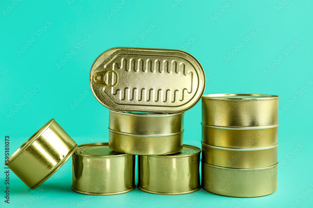 Tin cans with fish on turquoise background