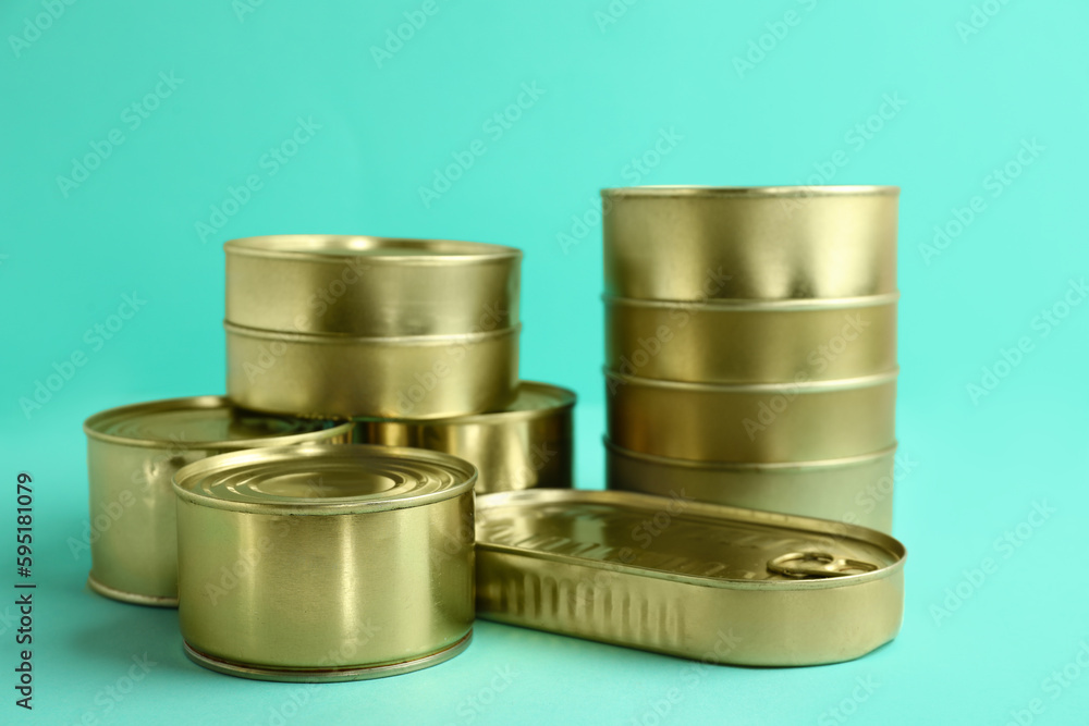 Tin cans with fish on turquoise background