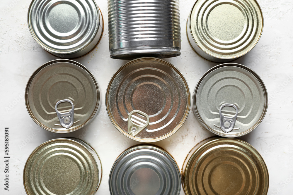 Assortment of tin cans with fish on white table