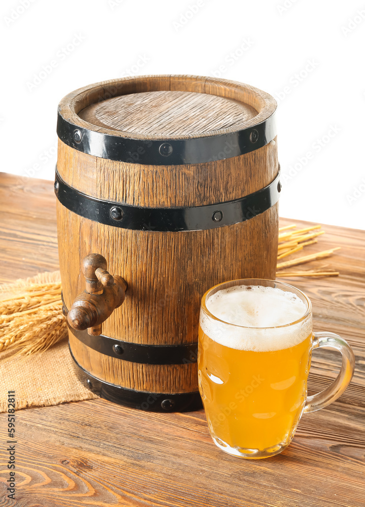 Wooden barrel and mug of cold beer on table against white background