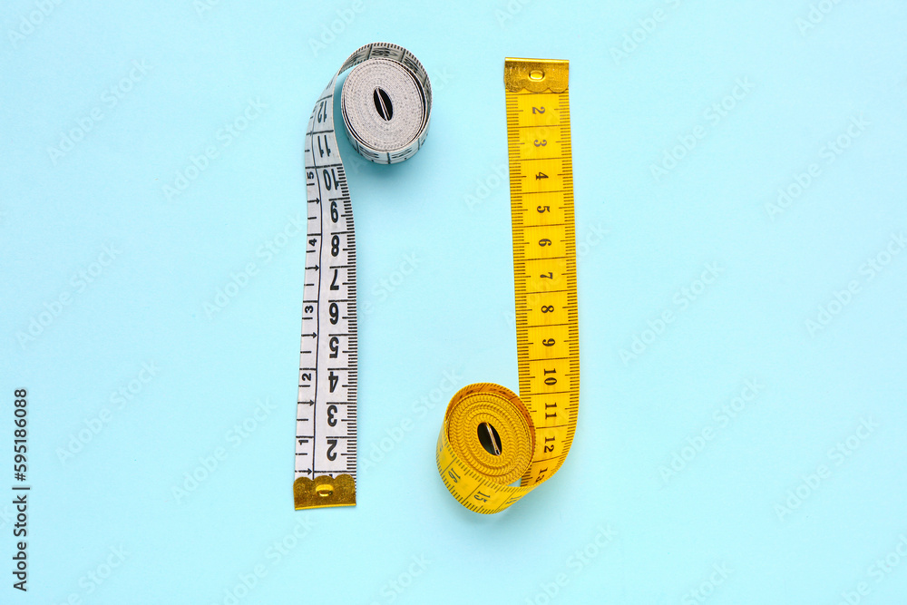 White and yellow measuring tapes on blue background