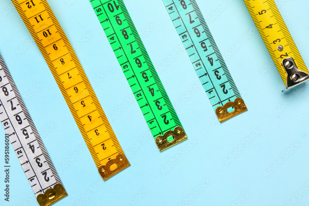 Colorful measuring tapes on blue background