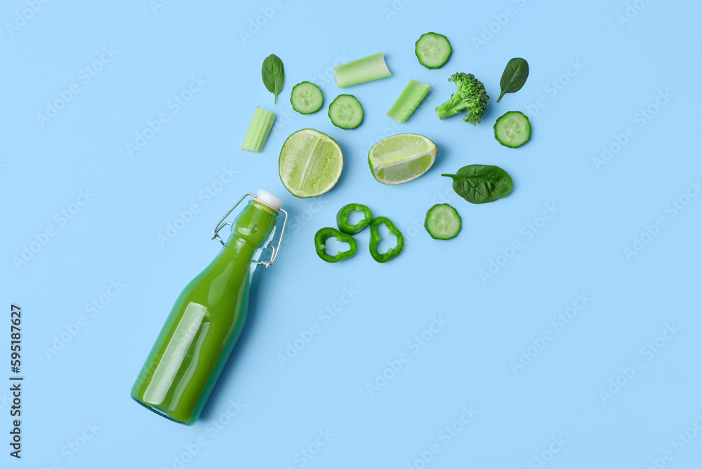 Glass bottle of tasty green juice and ingredients on blue background