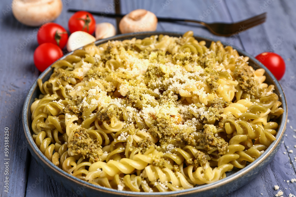 Plate of tasty Italian pasta with Parmesan cheese on wooden background