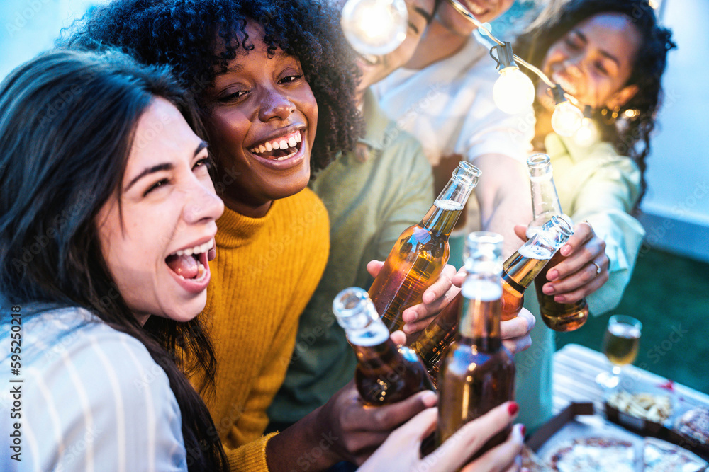 Happy friends enjoying party on rooftop terrace - Group of multiracial young people drinking beer bo