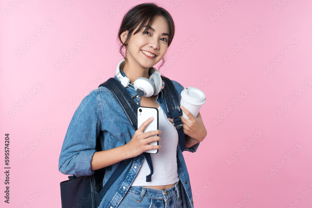 Portrait of young Asian woman student standing with smartphone coffee and backpack.College Teenager 