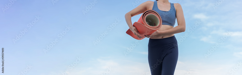 Woman hold yoga mat after exercising.outdoor exercise fitness concept