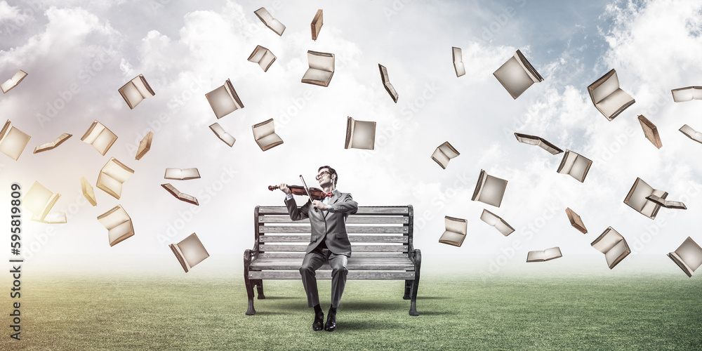 Handsome businessman in park on wooden bench play his melody