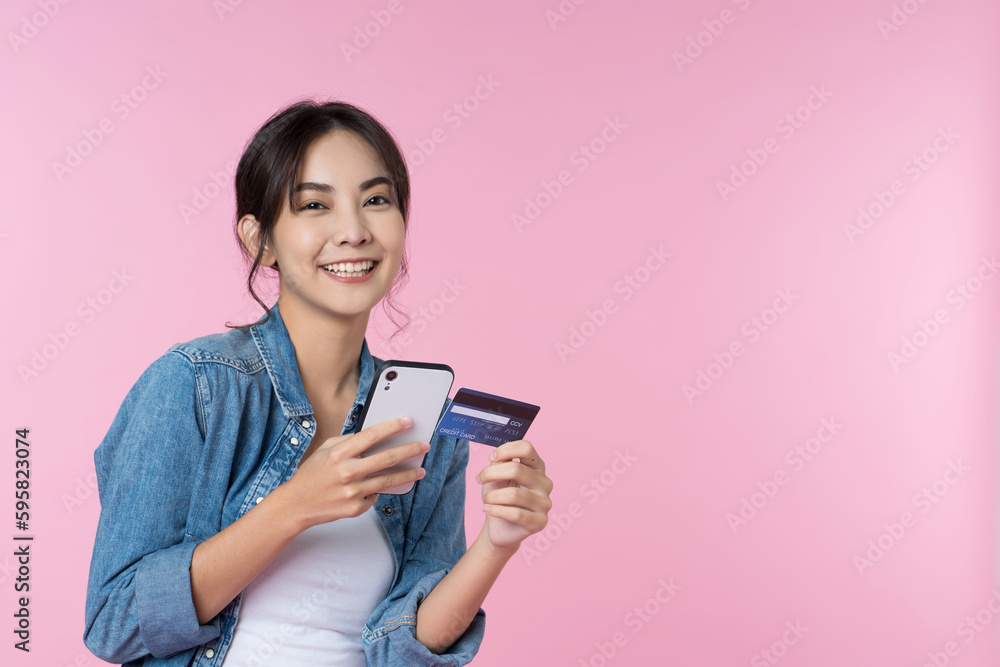 Young beauty Asian woman shopping payment online with credit card on smartphone and she wearing jean