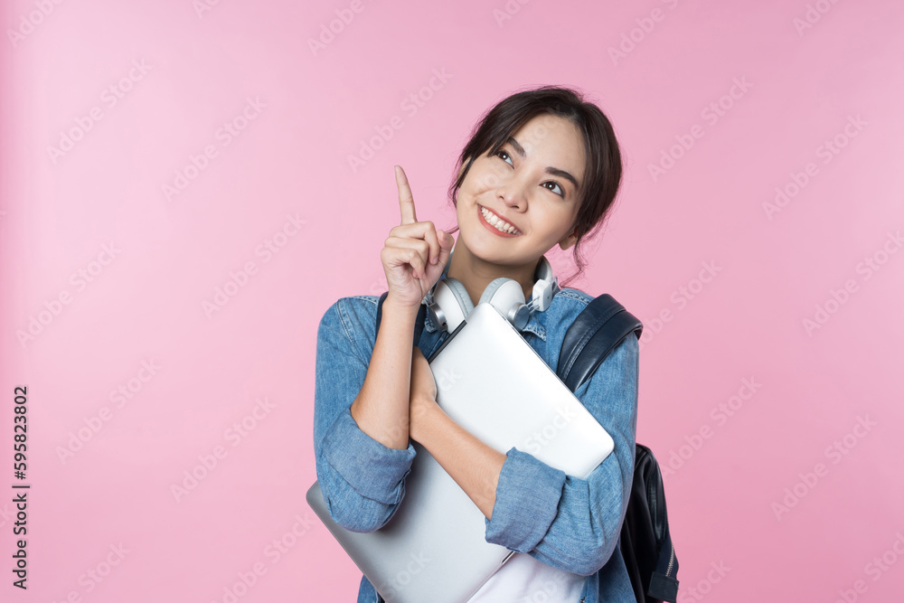 Young Asian woman texting message using mobile phone application on isolated brown background