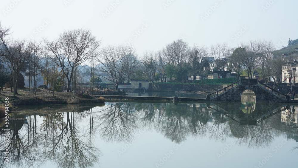 One old traditional Chinese village view with the old arched stone bridge and old wooden buildings i