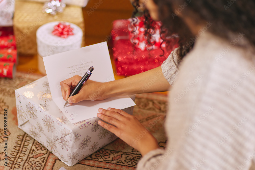 Merry Christmas, all my love. a unrecognisable woman writing a message in a card during Christmas at