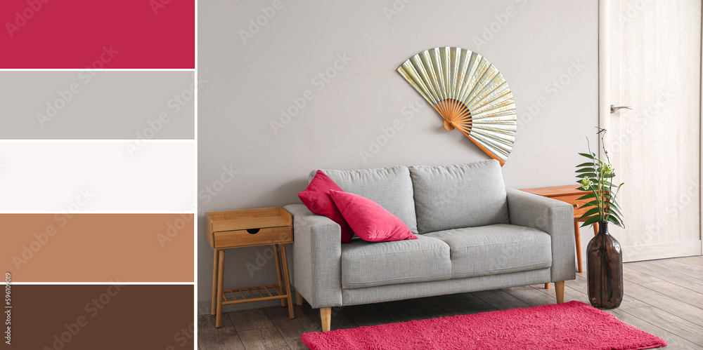 Interior of modern living room with grey sofa, wooden tables and ikebana. Different color patterns