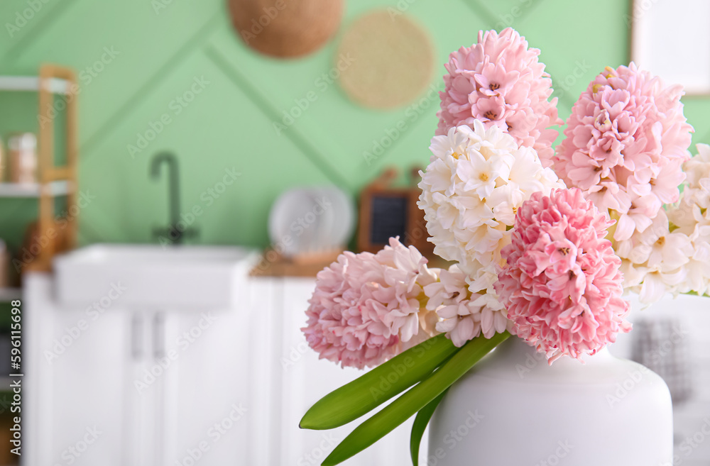 Vase with beautiful hyacinth flowers in kitchen, closeup