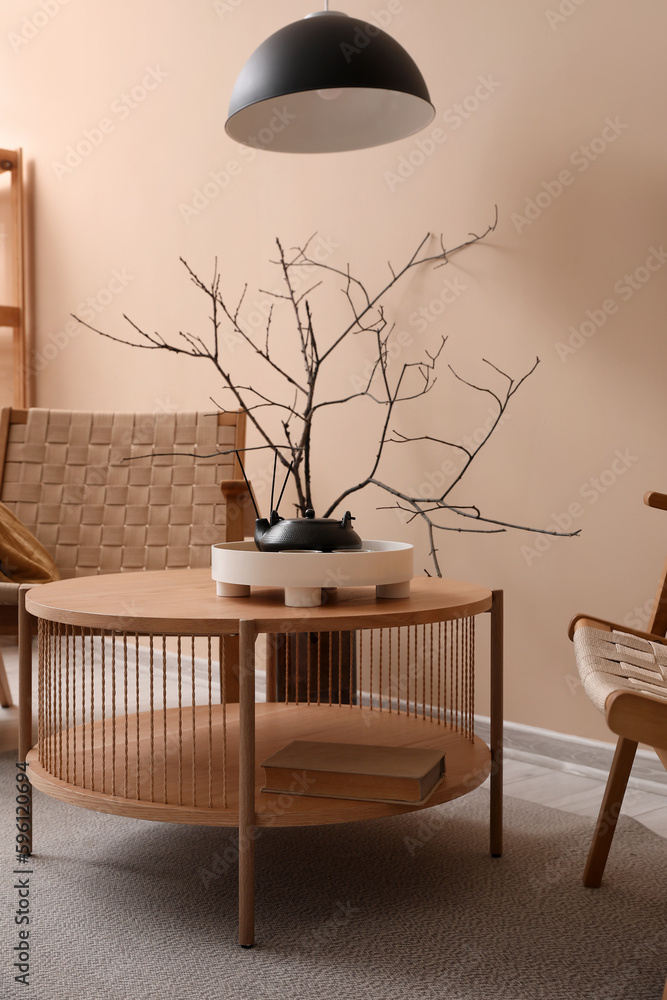 Coffee table with teapot, reed diffuser and book in living room