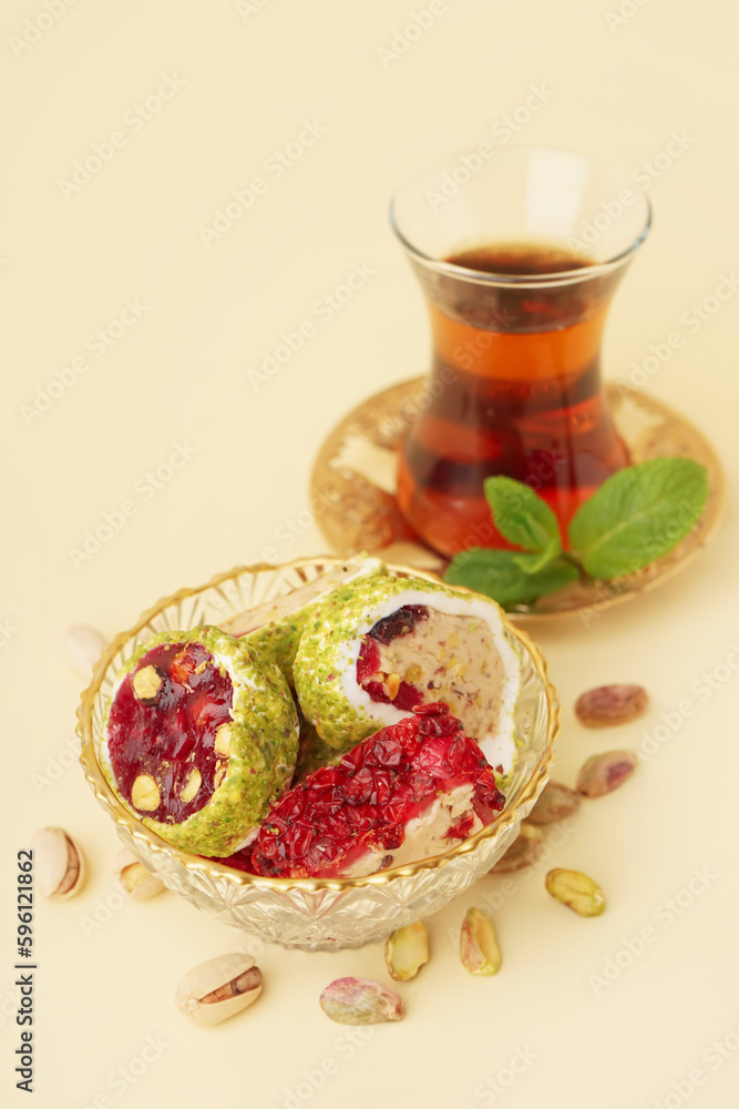 Bowl with tasty Turkish delight on yellow background