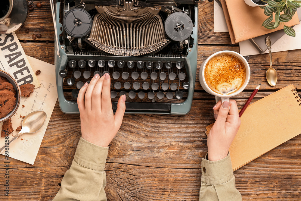 Woman with cup of coffee and typewriter on wooden table, closeup