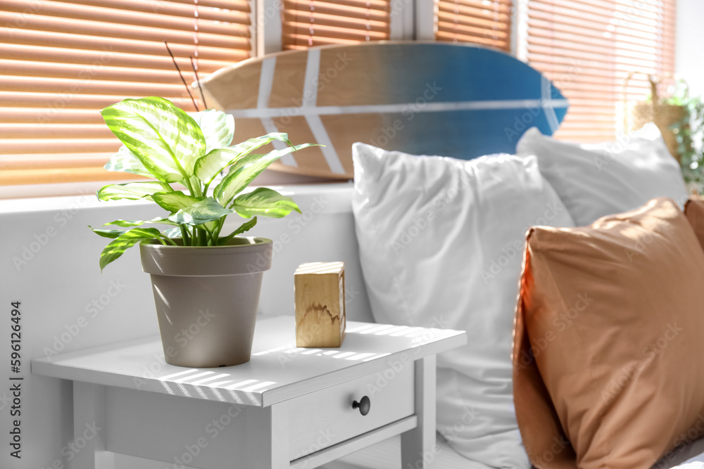 Table with houseplant in light bedroom