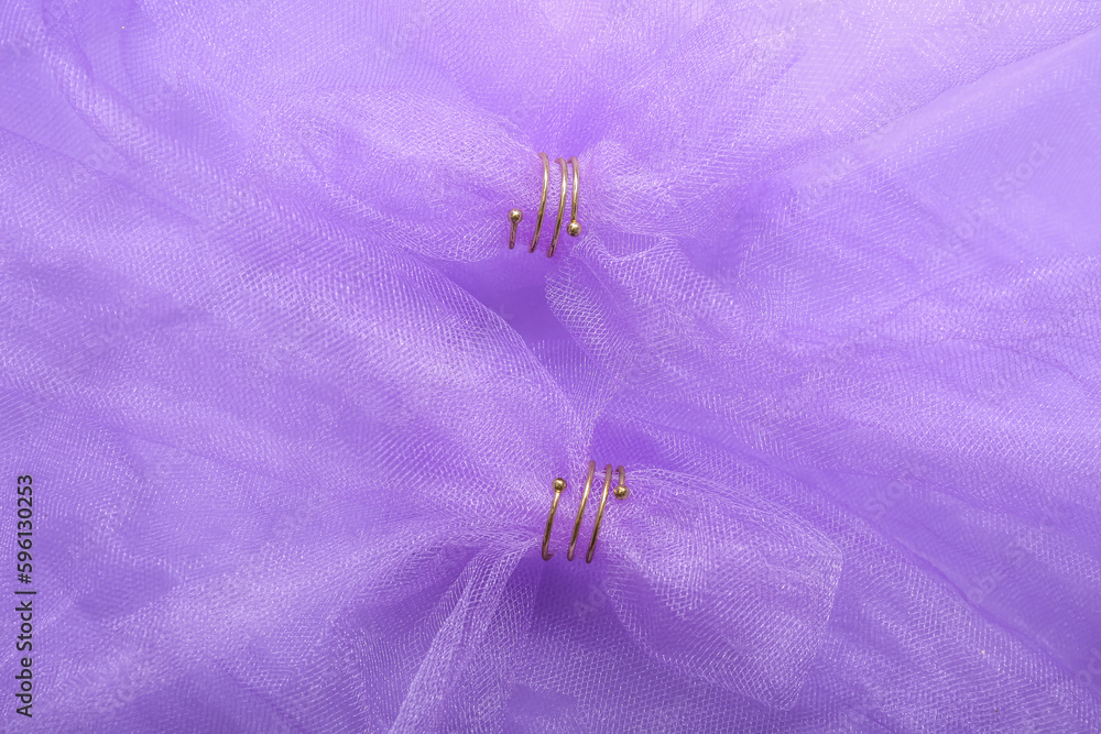 Veil with golden rings on lilac background