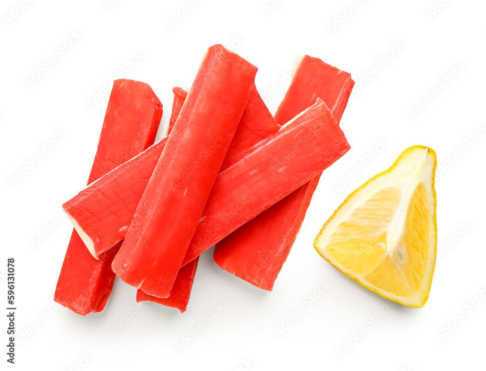 Tasty crab sticks with piece of lemon on white background