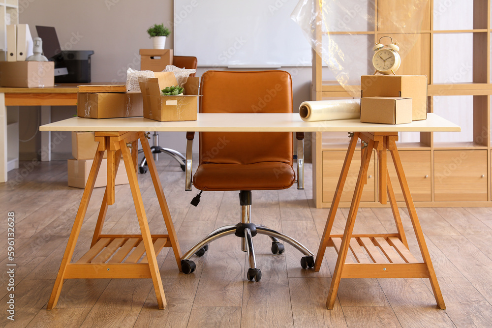 Workplace with cardboard boxes in office on moving day