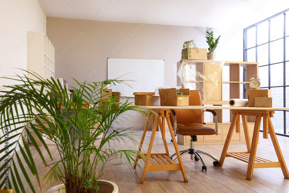 Workplace with cardboard boxes in office on moving day