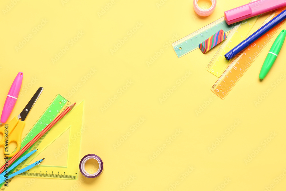 Colorful stationery supplies on yellow background