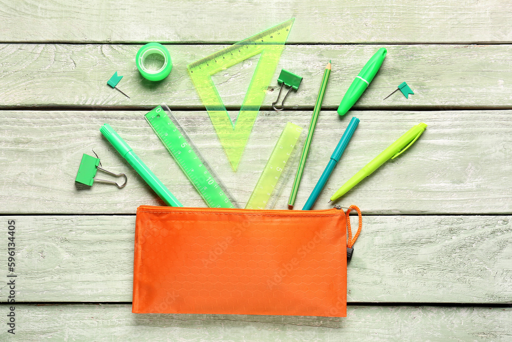 Stationery supplies on green wooden background