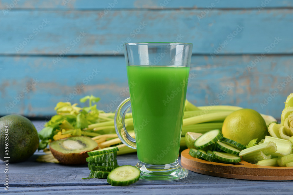 Glass of tasty green juice on blue wooden table