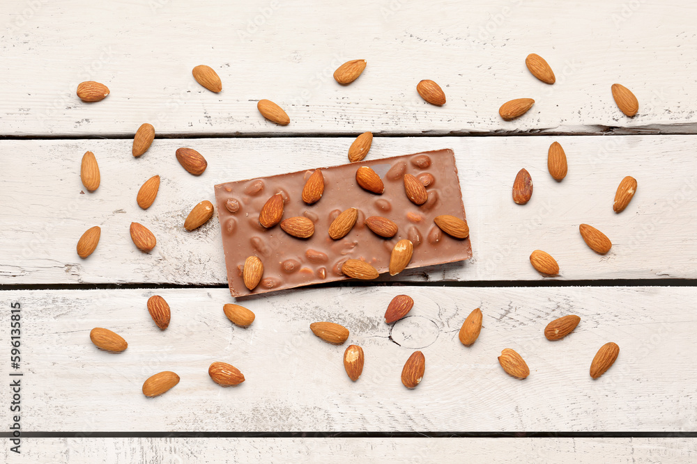 Sweet tasty chocolate with almonds on  light wooden background