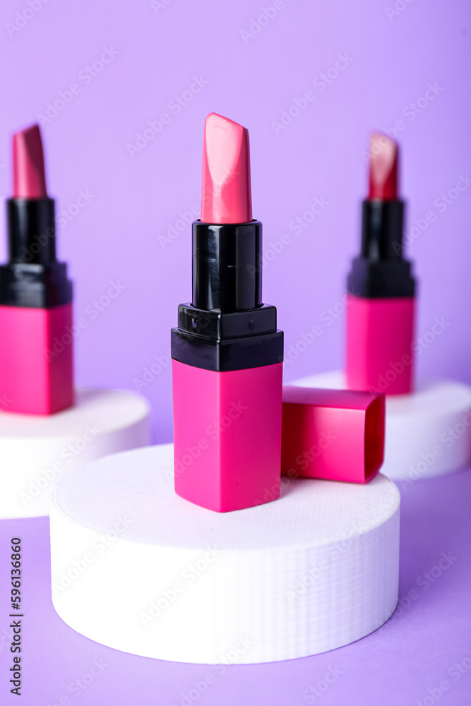 Decorative plaster podiums and lipsticks on lilac background