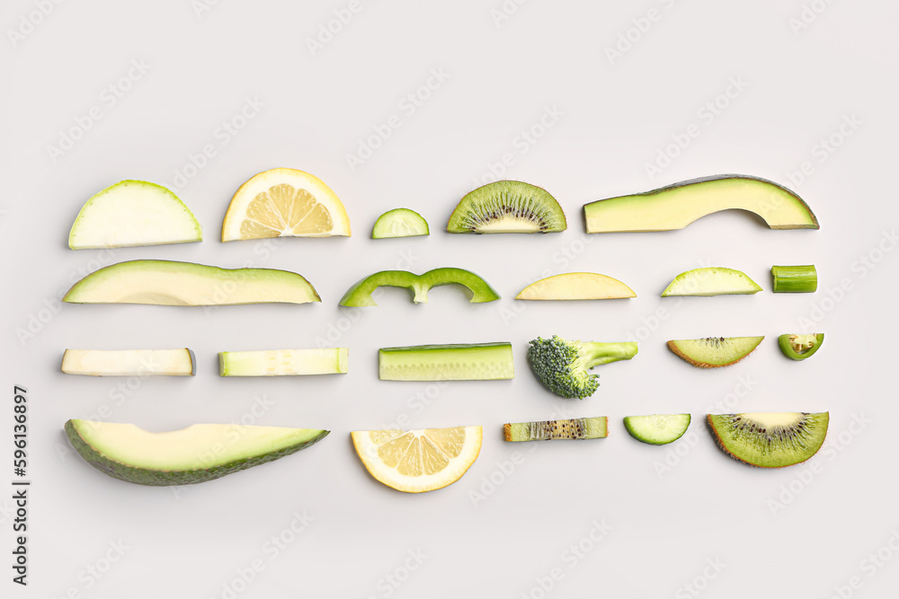 Composition with green fresh fruits and vegetables on grey background