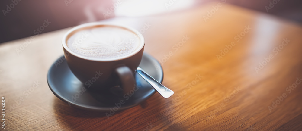 A cup of fresh coffee on the wooden table.