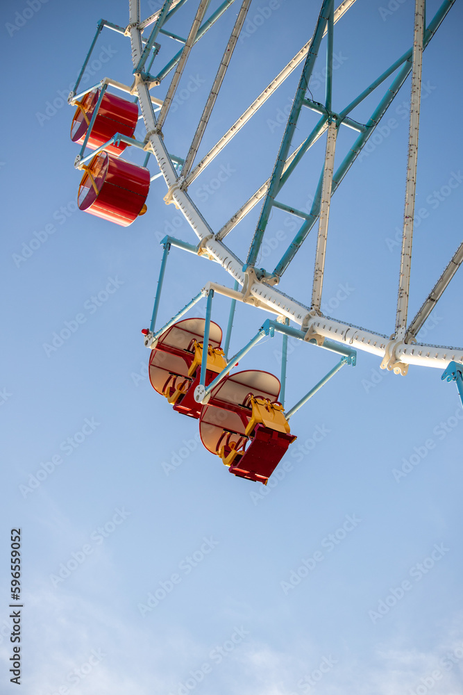 Ferris wheel, booths against the blue sky.