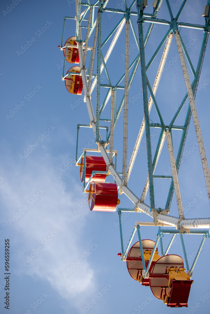 Ferris wheel, booths against the blue sky.