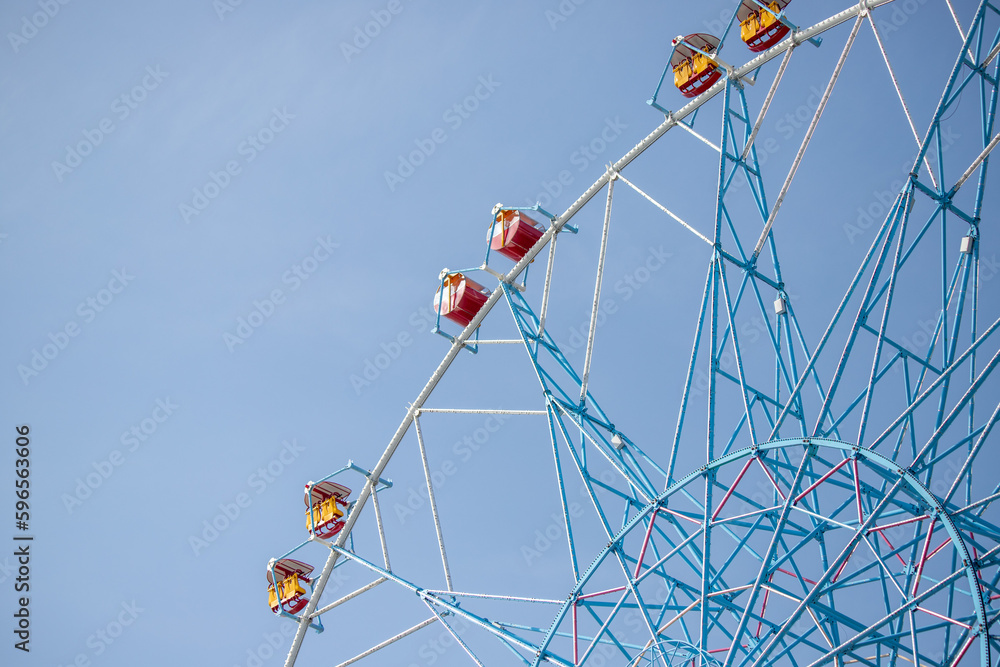 Ferris wheel, booths against the blue sky.