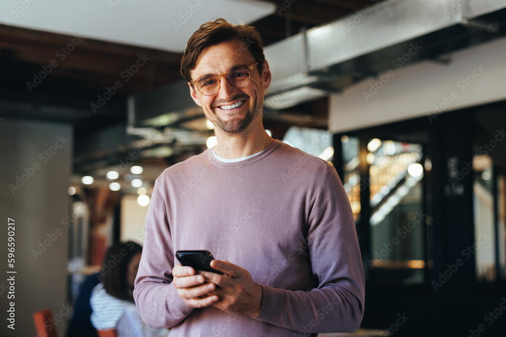 Portrait of a business man holding a cellphone in an office