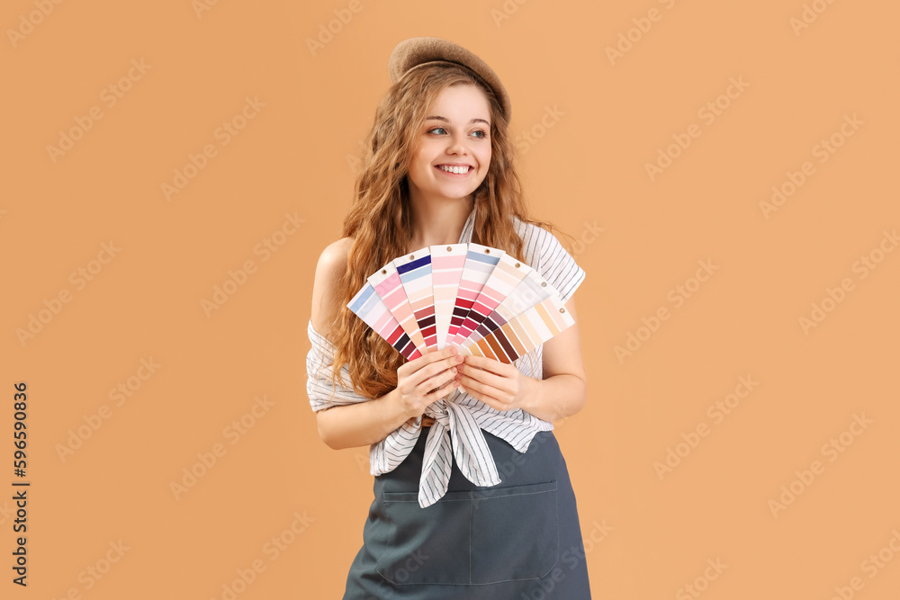 Female artist with paint color palettes on beige background