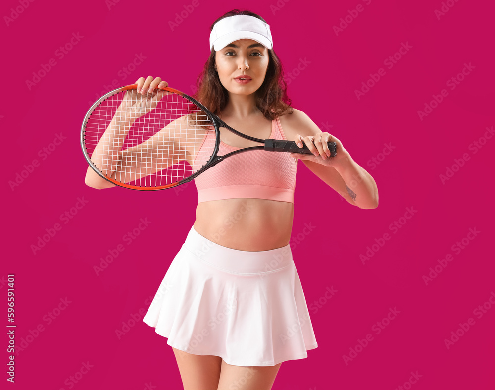 Young woman with tennis racket on pink background