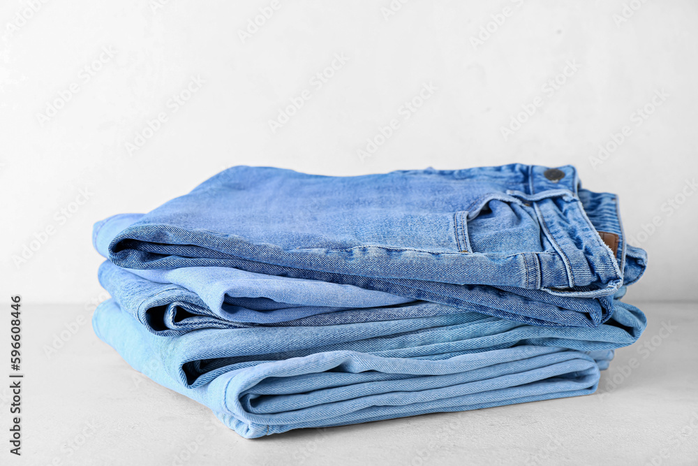 Stack of jeans on white background