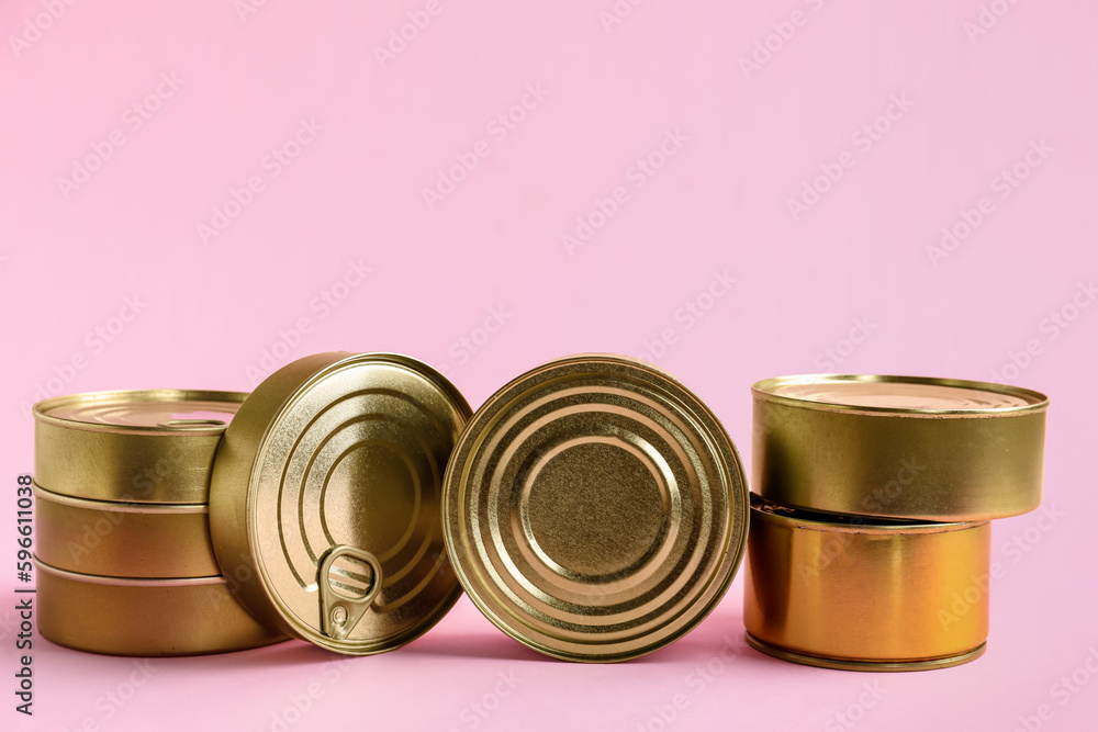 Tin cans with fish on pink background