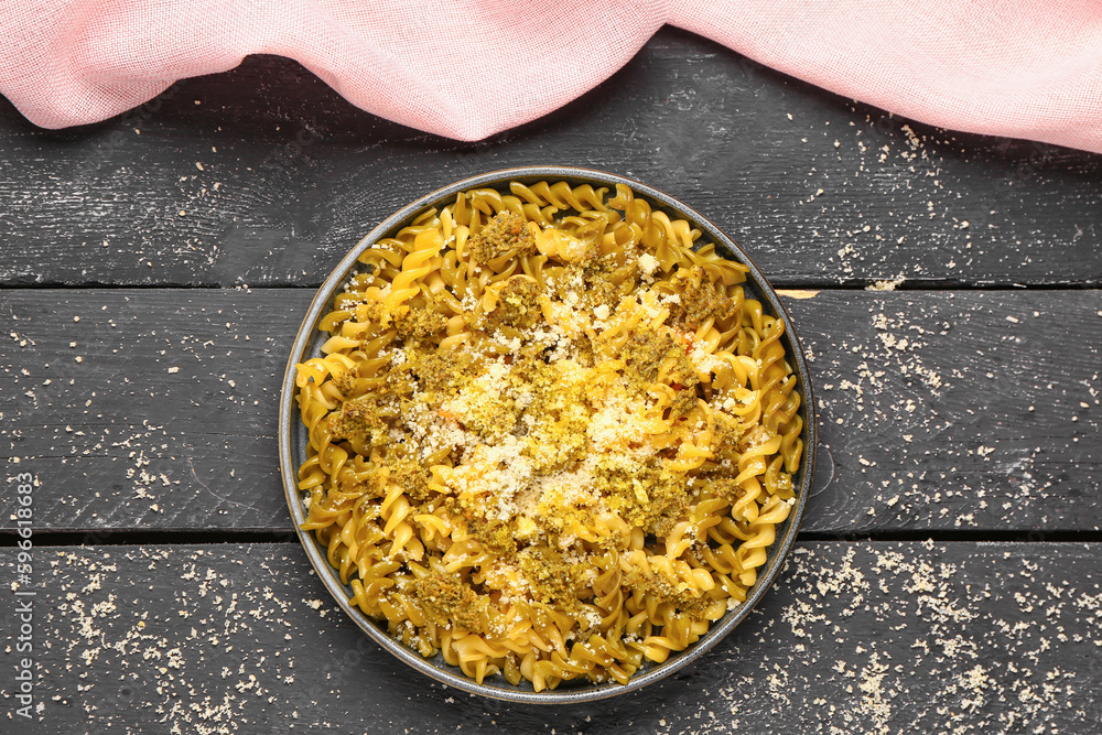 Plate of tasty Italian pasta with Parmesan cheese on dark wooden background