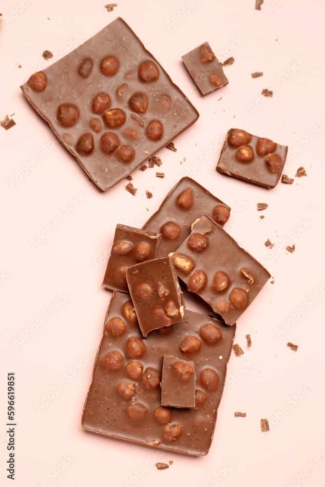 Sweet tasty chocolate with nuts on  light pink background