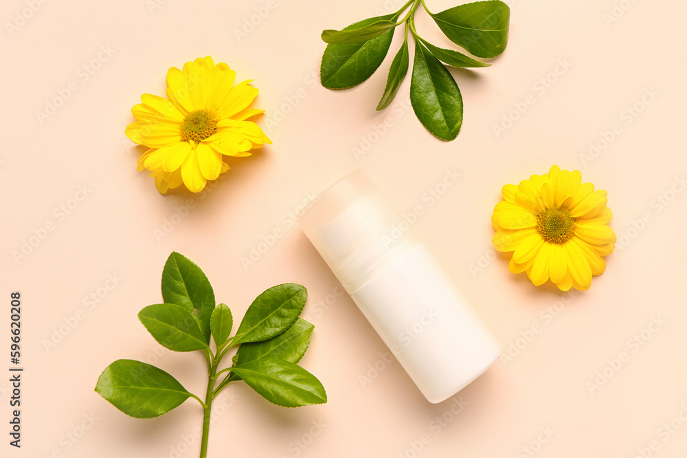 Deodorant with flowers and twigs on beige background