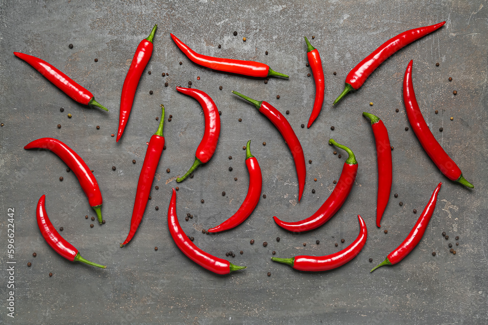 Fresh chili peppers with peppercorns on dark background