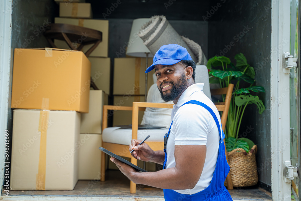 Delivery man checking list on clipboard near car before sending them to the homeowner.